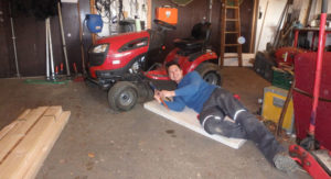 Junger Mann repariert einen Rasenmäher